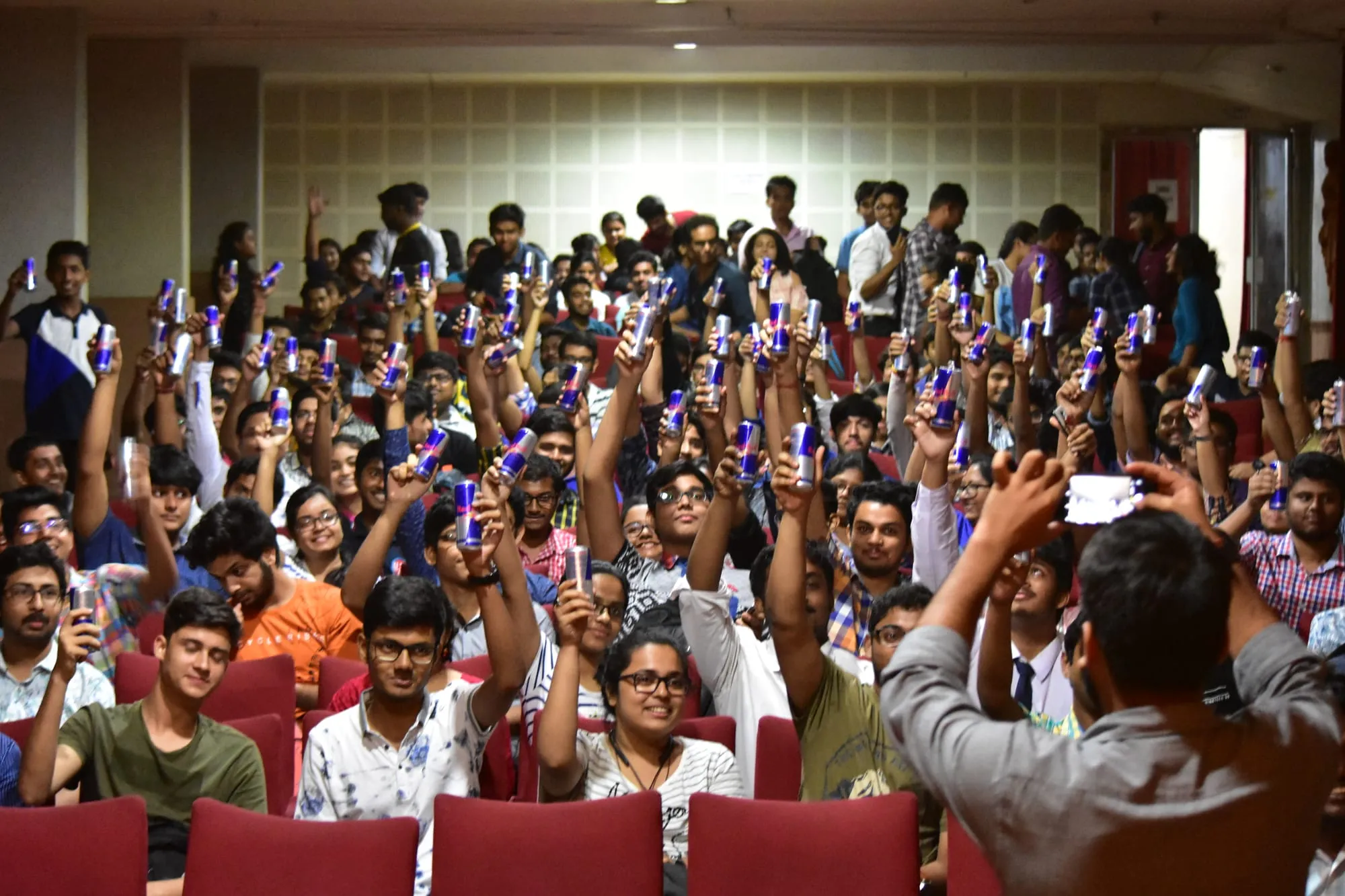 Students raising their hands and phones during a session.