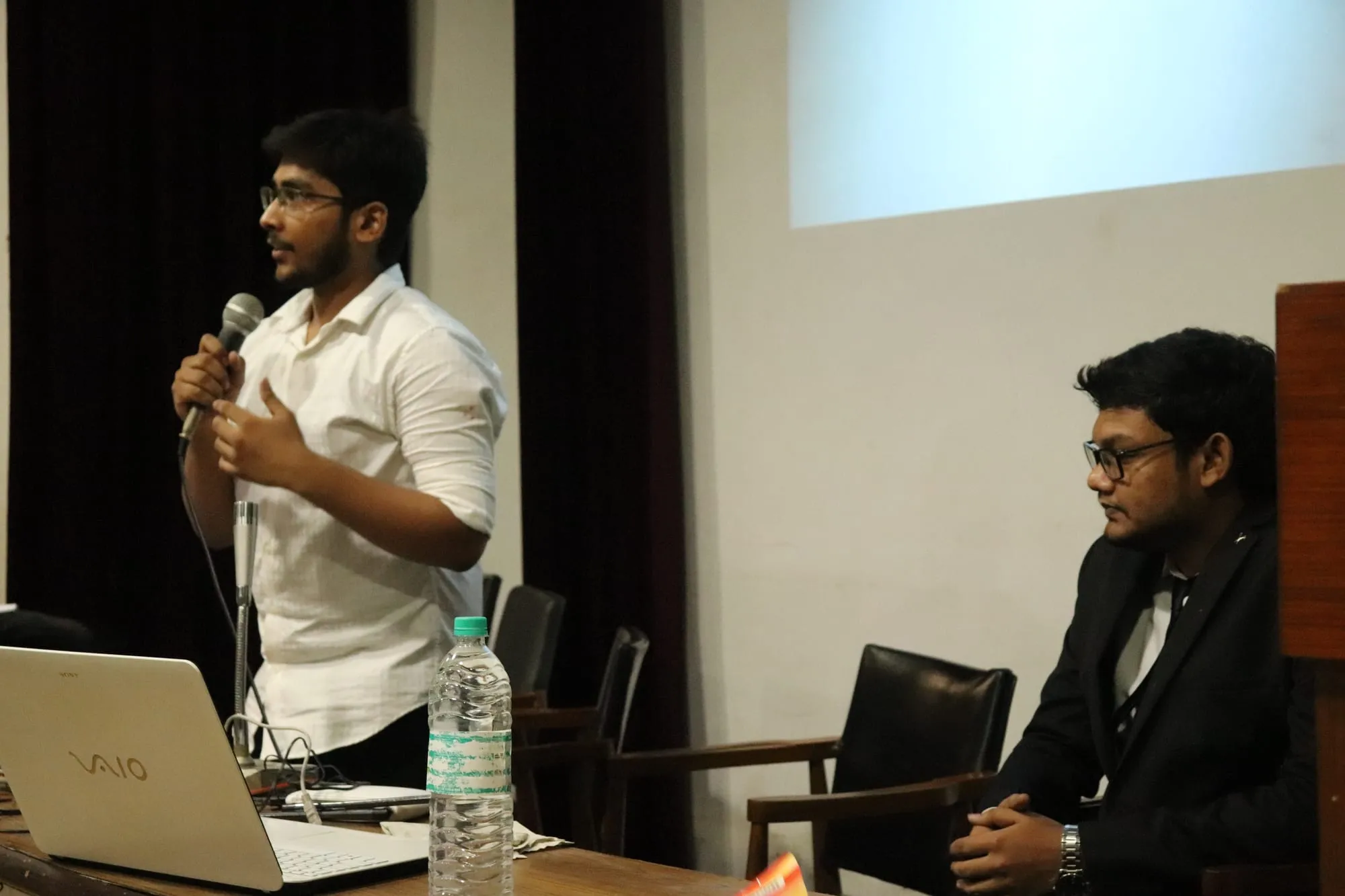 Sagnik Bhattacharya answering a question with a microphone in hand.